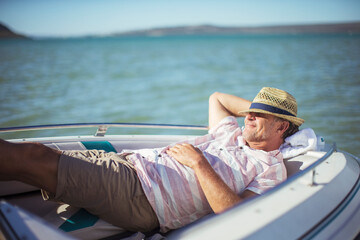 Older man relaxing in boat on water  - Powered by Adobe