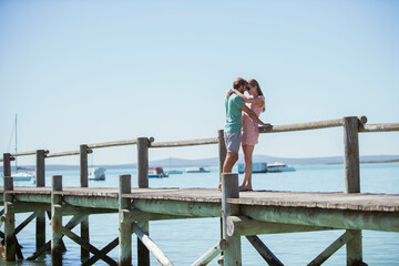 Couple hugging on wooden dock  