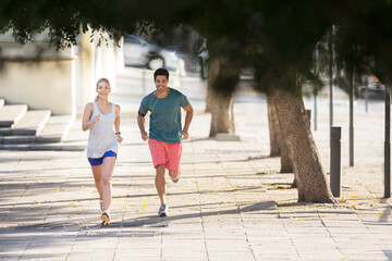 Couple running through city streets together