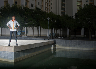Man standing in city park at night