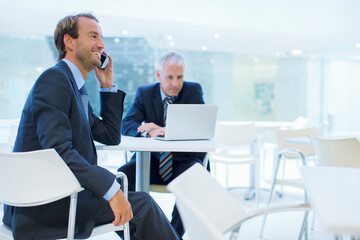 Businessman talking on call phone in office building cafe 