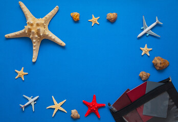 Top view of summer stuff. Travelling concept. Flat lay of Star fish passport and plans on the blue background. Summer backgrounds concept.  