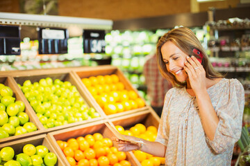 Woman talking on cell phone while shopping in grocery store