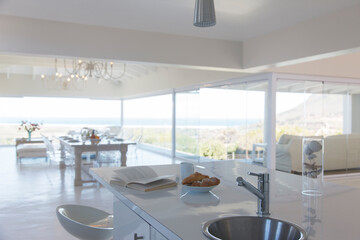 Book and plate of cookies on modern kitchen counter with sink