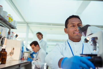 Fototapeta premium Scientist examining sample under microscope in laboratory