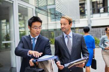 Businessmen talking outside of office building