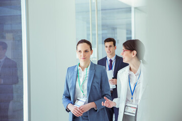 Scientist and businesswoman talking in hallway