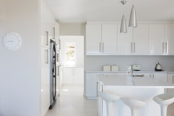 Modern white and clean kitchen interior with stools at counter
