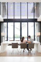 Couple using tablet computer in dining room