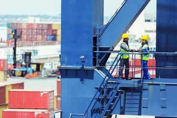 Worker and businessman shaking hands on cargo crane