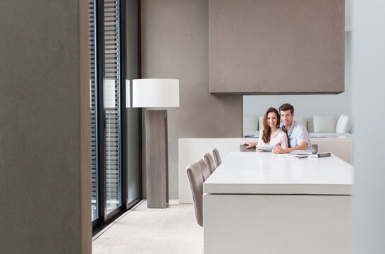 Portrait Of Couple With Tablet Computer In Dining Room