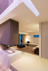 View of spacious modern living room with fireplace during night