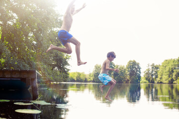 Father and son jumping into lake