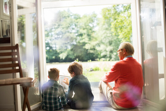 Grandfather and grandsons relaxing in doorway