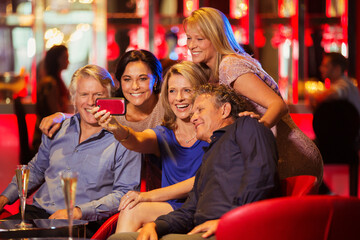 Group of mature friends taking selfie in nightclub