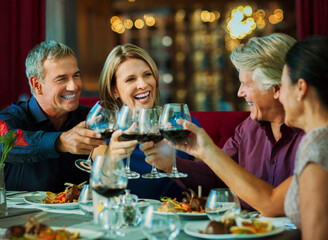 People toasting with red wine in restaurant