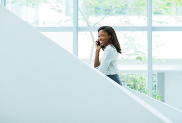 Businesswoman talking on cell phone on office stairs