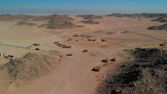 Top view of the Sahara desert, desert mountains. Wooden Bedouin houses. Sands.