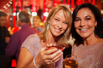 Naklejka premium Portrait of smiling mature women enjoying drink in bar