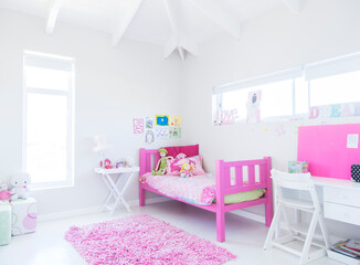 Girl's bedroom with pink bed, rug and toys