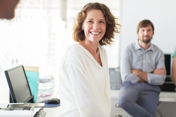Portrait of businesswoman in office, colleague in background