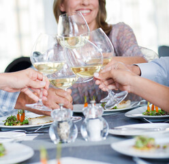 People toasting with white wine in restaurant