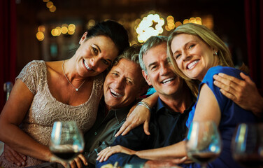 Portrait of smiling mature couples sitting together in restaurant