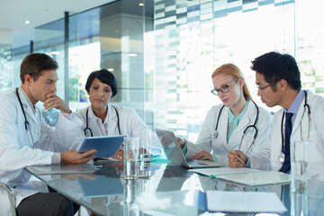 Fototapeta premium Doctors using laptop and discussing patient's treatment