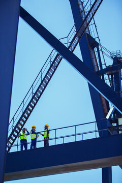 Low angle view of workers and businessman talking on cargo crane © Paul Bradbury/KOTO