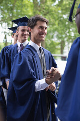 University students congratulating one another after graduation ceremony