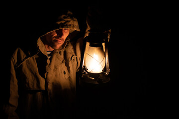 Sailor in a canvas raincoat at night with a kerosene lantern. 