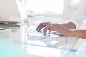 Hands of businesswoman typing on laptop in office