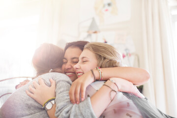 Obraz na płótnie Canvas Three teenage girls embracing at home