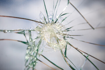 Broken Glass with Blue Sky and Clouds in Background.