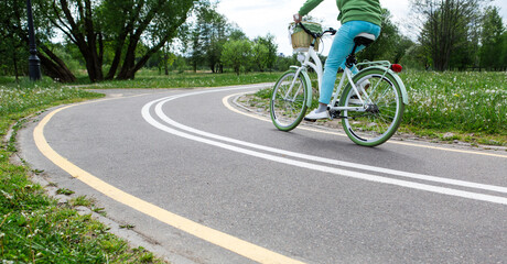 Woman riding a bike on bike path with markings in park