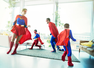 Superhero family chasing each other in living room