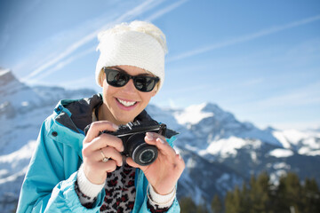 Fototapeta premium Portrait of smiling woman with camera at mountains