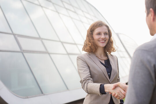 Business people shaking hands outdoors