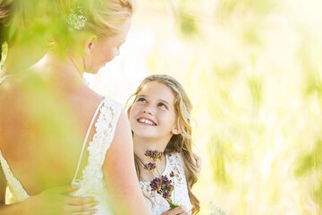 Fototapeta premium Smiling bridesmaid flowers bride during wedding reception in garden