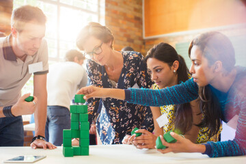 Creative business people stacking green blocks