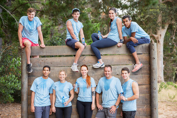 Portrait of confident team at wall on boot camp obstacle course