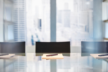 Part of modern conference room with table chairs, notepads and pens