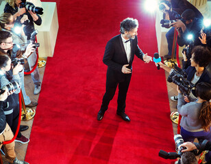 Celebrity on red carpet being interviewed photographed by paparazzi