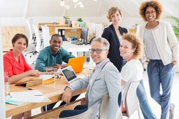 Group portrait of smiling office workers at table