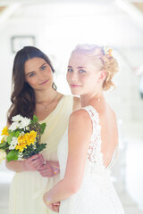 Portrait of bride bridesmaid with bouquet of flowers in domestic room