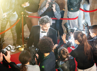 Celebrity being interviewed photographed by paparazzi photographers at red carpet event - obrazy, fototapety, plakaty