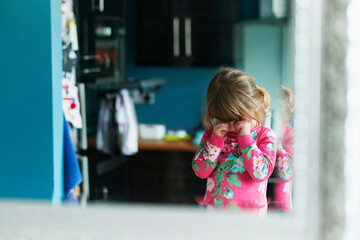 Reflection of upset girl rubbing eyes in mirror