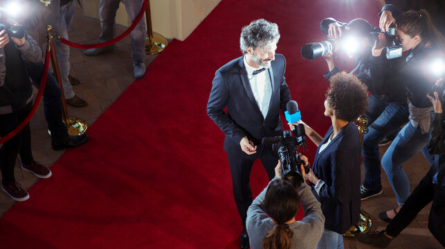 Celebrity being interviewed photographed by paparazzi photographers at red carpet event