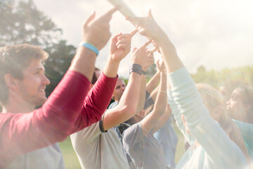 Team balancing pole overhead with fingertips