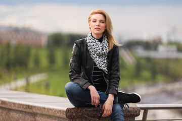 Happy young fashion woman in leather jacket and silk scarf